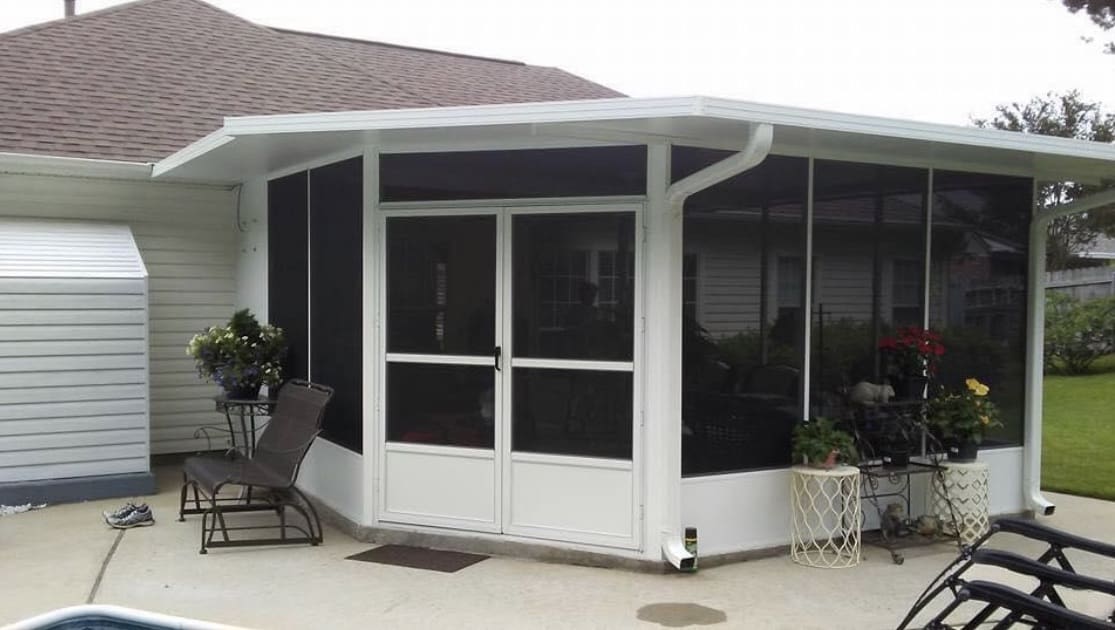 Screen room on a white home beside a pool